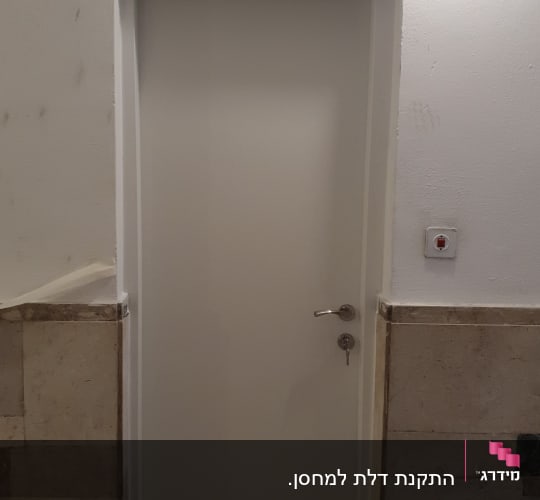 דלת לבנה עם ידית מתכת ומנעול